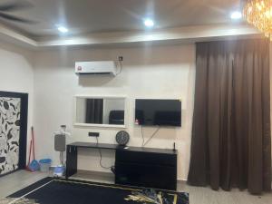 a living room with a flat screen tv on the wall at Umaira Roomstay Arau in Arau