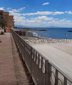 eine hölzerne Promenade neben einem Strand mit dem Meer in der Unterkunft Le Vele in Salerno