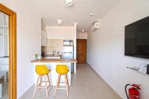 a kitchen with two yellow stools at a counter at Monolocale 19 in Rome