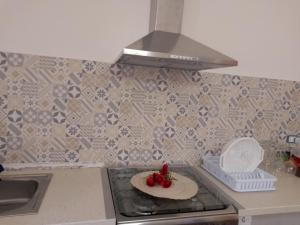 a kitchen with a plate of strawberries on the stove at Casa vacanze CARTIA in Ragusa