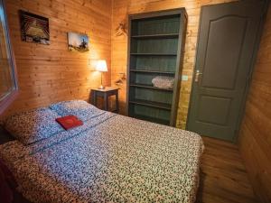 a bedroom with a bed with a red book on it at Chalet des noisetiers in Seix