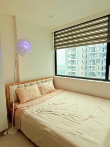 un lit dans une chambre avec une grande fenêtre dans l'établissement Sky Homestay Huế, à Thôn Văn Dương 8 autres photos