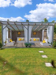a pergola with couches and pillows in a yard at Domki u Ewci - Domki całoroczne in Uherce Mineralne +13 photos