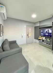 a living room with a couch and a flat screen tv at Estúdio no 27º Andar com Vista p/ Av. Afonso Pena in Campo Grande +27 photos