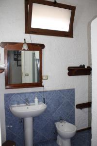 a bathroom with a sink and a mirror and a toilet at Villa con Pineta tra paese e mare in Favignana +51 photos