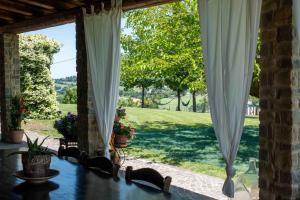 an open porch with curtains and a view of a yard at B&B La Casa del Gallese in Sorbolongo
