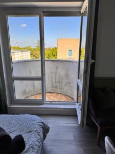 1 dormitorio con vistas a un balcón en Chambre tropicale 3, en Courcouronnes