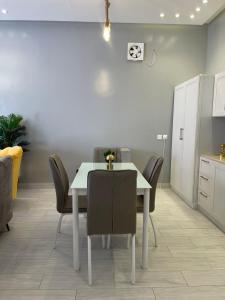 a dining room with a white table and chairs at شاليهات جاليكا in Taif