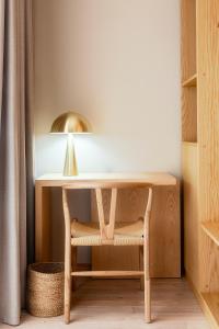 a table with a chair and a lamp on it at Quinta da Torre - Anselmo Mendes 