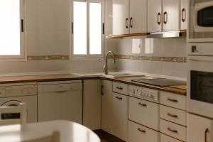 a kitchen with white cabinets and a sink at Albaceteloft Avenida España in Albacete +22 photos
