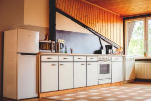 a kitchen with white appliances and a large window at Eulennest in Neu Drefahl