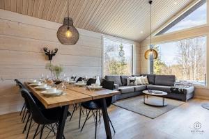 a dining room with a table and a couch at Villa Cloudberry by Hilla Villas in Kittilä