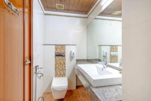 łazienka z umywalką, toaletą i lustrem w obiekcie Calm Living in the City w mieście Gurgaon