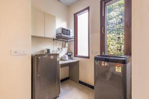 małą kuchnię z lodówką i oknem w obiekcie Calm Living in the City w mieście Gurgaon