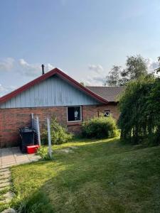 a brick house with a grass yard in front of it at Joy house in Munkebo