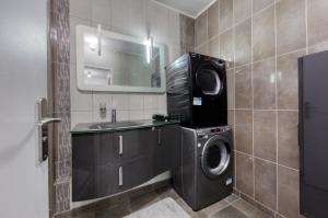 Un baño con lavadora y lavabo. en Chambre tropicale 3, en Courcouronnes
