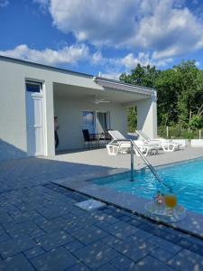 a swimming pool in front of a house at Z House kuća za odmor in Blagaj