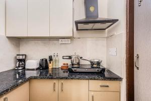 a kitchen with a stove and a counter top at Eco-chic haven in Gurgaon with balcony in Gurgaon