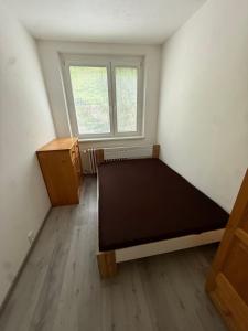 una piccola stanza con un letto e una finestra di Apartmán s veľkou terasou v srdci Trenčína a Trenčín
