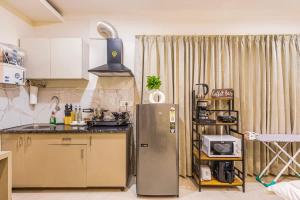 kuchnia z lodówką i mikrofalówką w obiekcie Penthouse with Jacuzzi steam bath &foot massage w mieście Gurgaon