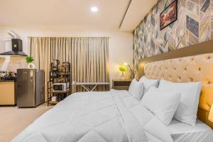 sypialnia z dużym białym łóżkiem i kuchnią w obiekcie Penthouse with Jacuzzi steam bath &foot massage w mieście Gurgaon +12 zdjęć