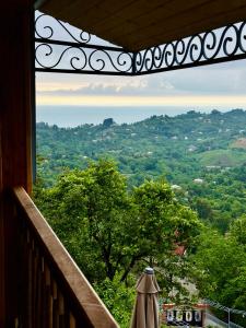 a room with a balcony with a view of trees at Roots Resort in Kobuleti