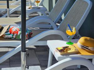 une chaise blanche avec un chapeau et une boisson dessus dans l'établissement Apartment Tomic 2, à Makarska