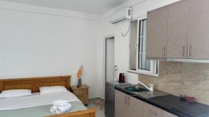 a kitchen with a bed and a sink in a room at Vila Bedro in Sarandë