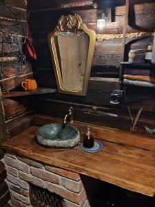 a bathroom with a stone sink and a mirror at Dzwonkarnia in Dzwonkowice