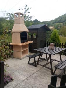 una mesa de picnic y una parrilla en el patio trasero en La Cuestina, en Onís