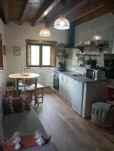 Una cocina con un sofá y una mesa en una habitación. en La Cuestina, en Onís