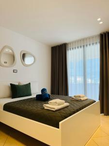 a bedroom with a large bed with towels on it at Villa White in Ksamil