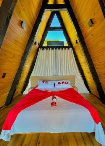 ein Bett in einem Holzzimmer mit Fenster in der Unterkunft Chales Caixa Daco in Porto Belo + 15 Fotos