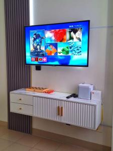 a flat screen tv on top of a white dresser at Hills Staycation by SDC in Manila