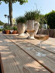 three glasses of wine sitting on a wooden table at 1920Renesse in Renesse
