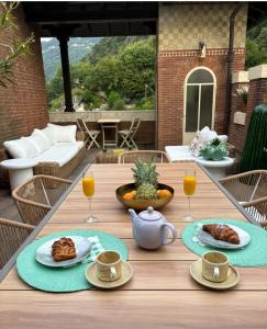 a table with plates of food and drinks on a patio at VILLA GAETA Penthouse in Nobiallo