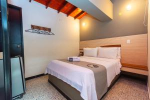 a hotel room with a bed with a camera on it at Mandala Medellin Botero By GyC Hotels in Medellín
