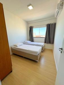 En eller flere senge i et værelse på Resort Aruana com 2qts, ar, piscina e muito verde