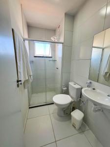 Et badeværelse på Resort Aruana com 2qts, ar, piscina e muito verde