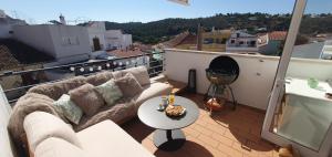a living room with a couch and a table on a balcony at Casa Portao da Cidade in Silves