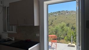 a kitchen with a view of a mountain from a window at Vila Bedro in Sarandë