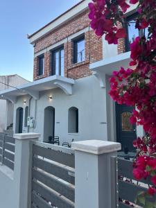 a house with a fence and pink flowers at Arch Residence, studio 1, Apothika in Katarráktis