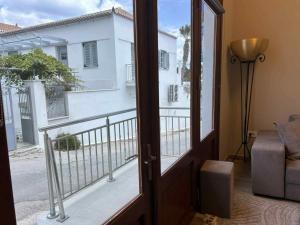 a door to a balcony with a view of a building at Baltiza Loft in Spetses