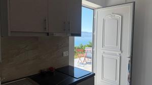 a kitchen with a view of the ocean from a door at Vila Bedro in Sarandë