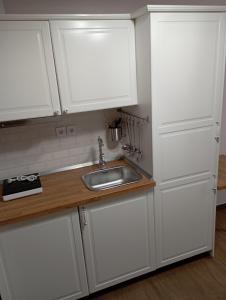 a kitchen with white cabinets and a sink at Storks apartments in Korinós
