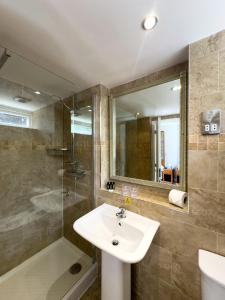 a bathroom with a sink and a shower and a mirror at The Mount Country Manor Hotel & Golf Wolverhampton in Wolverhampton