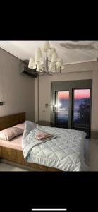a bedroom with a bed and a chandelier at Luxury Apartment Sea View Chalkida in Chalkida