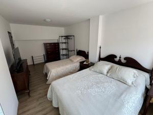 a bedroom with two beds and a dresser at Kultura Apartment in Skopje