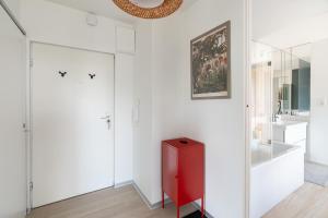 a bathroom with white walls and a red cabinet at TreeTop Studio near MTP in Poznań +6 photos