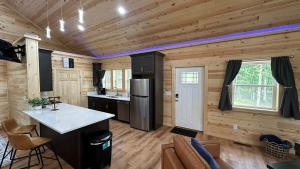 a kitchen in a log cabin with wooden walls at Brand New Luxury Cabin Full of Amenities 